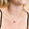 Close Up of Model Wearing Interlocking Crystal Hearts Necklace in Gold