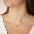 Close Up of Model Wearing Interlocking Hearts Necklace in Gold