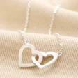 Interlocking Hearts Necklace in Silver on Beige Fabric