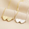 Linked Hearts Pendant Necklace in Silver Next to Gold Version on Beige Fabric