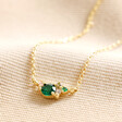 May Birthstone Cluster Necklace in Gold on Beige Fabric