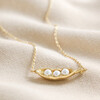 Pearl Three Peas in a Pod Pendant Necklace in Gold on Beige Fabric