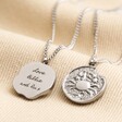 Personalised Stainless Steel Zodiac Pendant Necklace on top of neutral coloured fabric with front and back of pendant