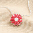 Pink Enamel Daisy Pendant Necklace in Silver on top of beige coloured material