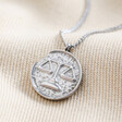 Close up of the Stainless Steel Libra Pendant Necklace on beige material