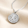 Close up of the Stainless Steel Sagittarius Pendant Necklace on beige fabric