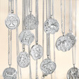 Personalised Stainless Steel Zodiac Pendant Necklaces dangling in front of neutral background