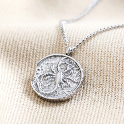 Stainless Steel Scorpio Pendant Necklace on Beige Fabric