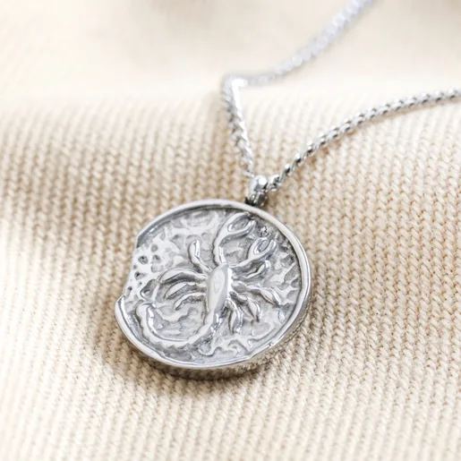 Stainless Steel Scorpio Pendant Necklace on Beige Fabric