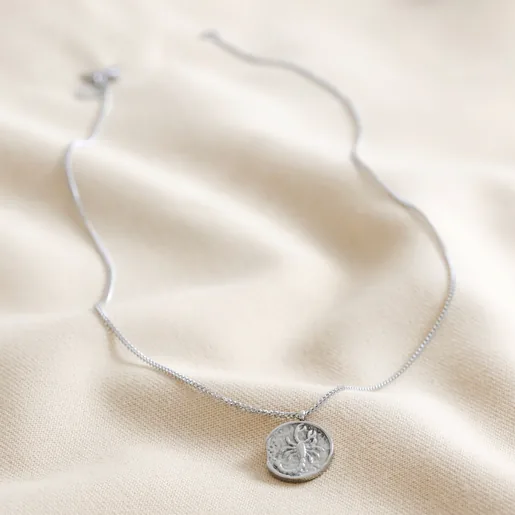 Full Chain of Stainless Steel Scorpio Pendant Necklace on Beige Fabric