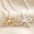 Tiny Pearl Bow Pendant Necklaces in Silver and Gold on Cream Background