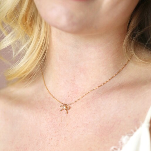 Tiny Pearl Bow Pendant Necklace in Gold Tiny Pearl Bow Pendant Necklace in Gold Close Up on Model