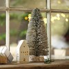 Small Light Up LED Tree Ornament on top of wooden counter with ceramic house ornament next to it