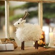 Snowy White Reindeer Ornament in Lifestyle Shot in Front of Window with Decorations Around