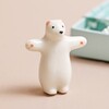 Ceramic Bear token standing outside of the Tiny Matchbox Ceramic Bear Token packaging