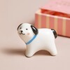 Ceramic Dog token standing outside of the Tiny Matchbox Ceramic Cat Token packaging