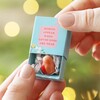 Model holding the Tiny Matchbox Ceramic Robin Token in front of blurred Chritmas tree