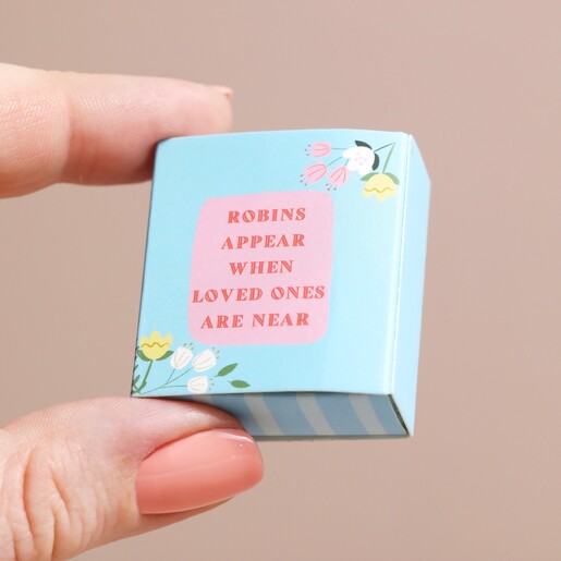 Tiny Matchbox Ceramic Robin Token Model holding the Tiny Matchbox Ceramic Robin Token packaging between fingers