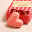 Tiny Matchbox Love You Ceramic Heart Token In Front of Box on Beige Surface