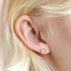 Close up of Red Enamel Flower Stud Earrings in Gold on blonde model