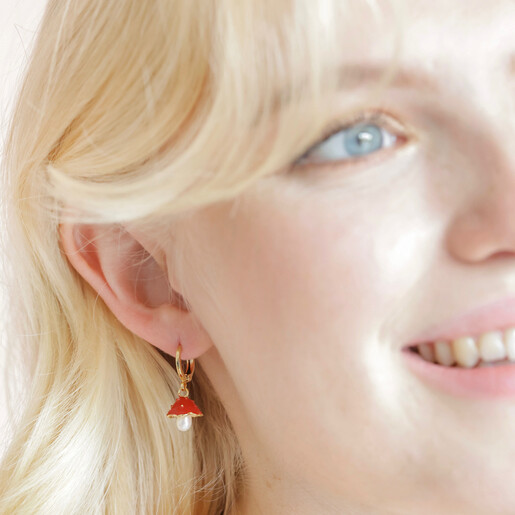 Enamel Toadstool and Pearl Huggie Hoop Earrings in Gold on model smiling