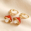 Enamel Toadstool and Pearl Huggie Hoop Earrings in Gold on top of neutral coloured fabric