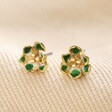 Green Enamel Flower Stud Earrings in Gold on top of neutral coloured fabric