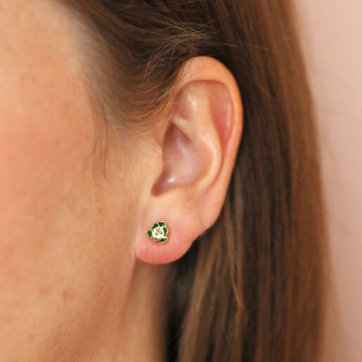 Close up of Green Enamel Flower Stud Earrings in Gold on brunette model in front of natural coloured backdrop