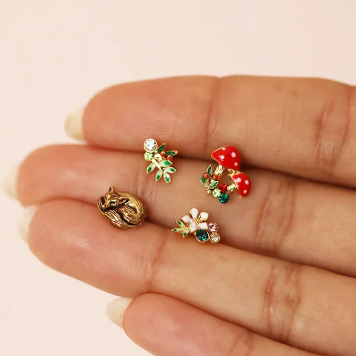Model Holding Set of Four Enamel Woodland Stud Earrings in Gold