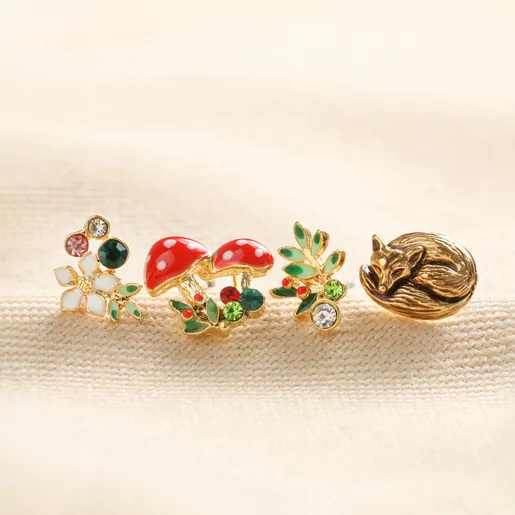 Set of Four Enamel Woodland Stud Earrings in Gold in a Line on White Surface