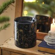 Back of Blue Starry Night Wax Burner on top of wooden counter in lifestyle shot in front of mirror with candle to the side