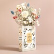 Ceramic Little Book of Flowers Vase with flowers inside in front of beige coloured backdrop