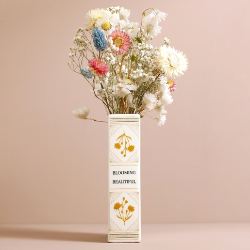 Spine of Ceramic Little Book of Flowers Vase with flowers inside against beige coloured backdrop