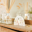 Dusky Pink Floral Bee Ceramic Earring Holder in lifestyle shot with reed diffuser