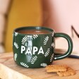 Ceramic Green Leafy Papa Mug with tea inside on top of wooden counter