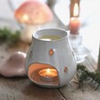 Pink Ceramic Toadstool Wax Burner in lifestyle shot on top of wooden counter with lit candle inside and melted wax in the top