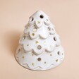 Top of White Ceramic Christmas Tree Tealight Holder against beige coloured surface