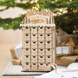 Personalised Wooden Forest Cutout Advent Calendar underneath Christmas tree with presents behind