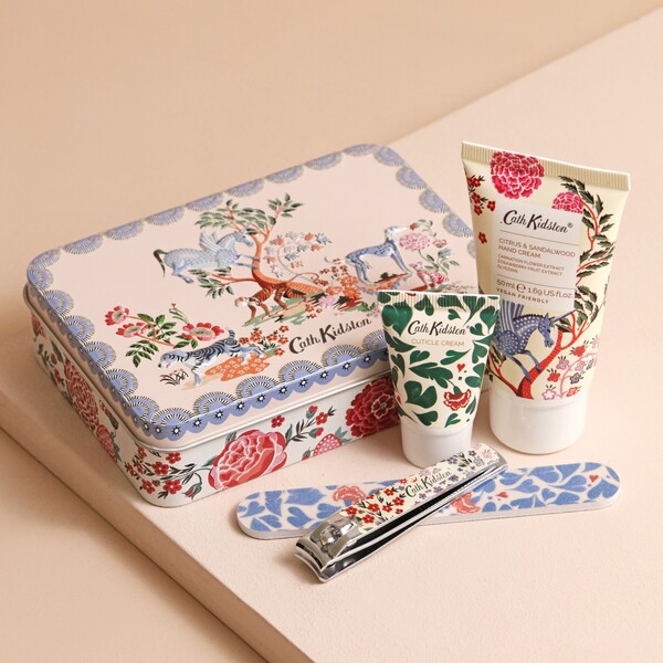 Cath Kidston The Artist's Kingdom Nail Care Kit laid out on top of pink coloured backdrop with products outside of tin