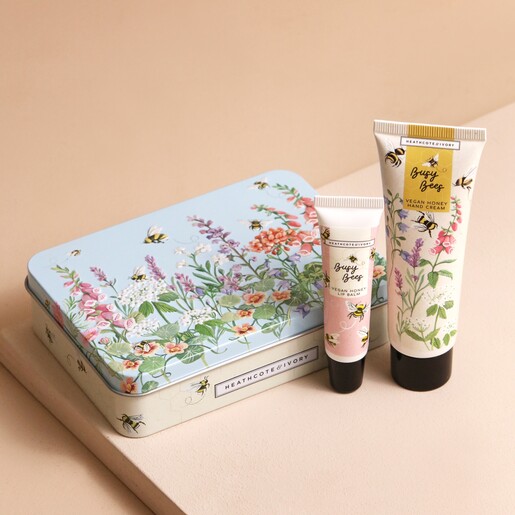 Heathcote & Ivory Busy Bees Vegan Honey Hand & Lip Tin with Products Standing Outside of Tin on Beige Background