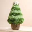 Jellycat Amuseable Nordic Spruce Christmas Tree Soft Toy on top of raised surface with neutral coloured background