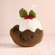 Jellycat Plush Festive Folly Christmas Pudding Decoration against neutral coloured background with snow