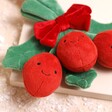 Close up of berries on Jellycat Amuseable Holly Soft Toy against beige coloured surface