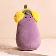 Jellycat Toastie Vivacious Aubergine Soft Toy on top of pink coloured raised surface