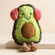 Jellycat Toastie Amuseable Avocado Soft Toy perched on top of a raised surface with neutral background