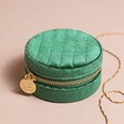 Quilted Velvet Mini Round Travel Jewellery Case in Green Closed on Beige Background