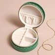Quilted Velvet Mini Round Travel Jewellery Case in Green Open on Beige Surface