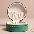Close Up of Quilted Velvet Mini Round Travel Jewellery Case in Green Interior Lid on Beige Background 