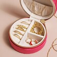 Quilted Velvet Mini Round Travel Jewellery Case in Pink Interior filled with Gold Jewellery on Neutral Toned Surface