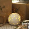 Ceramic LED Celestial Ball Light under Christmas tree with presents
